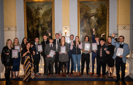 Student award winners grouped together holding their awards smiling at the camera