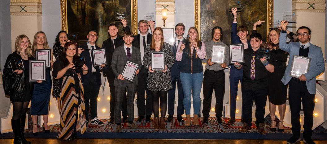 Group of student award winners holding their certificates and awards smiling at the camera