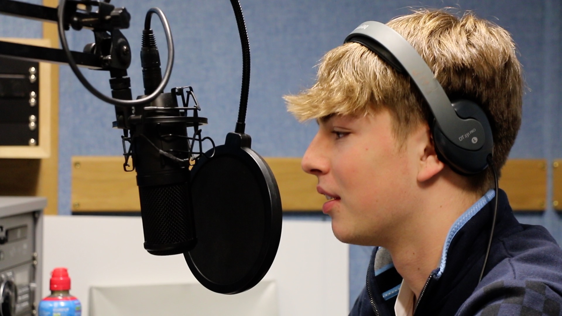 Student speaking into radio mic with headphones on