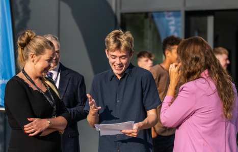 A student opens his results and smiles