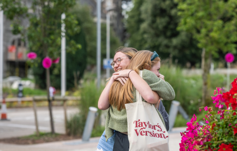 Two students hug