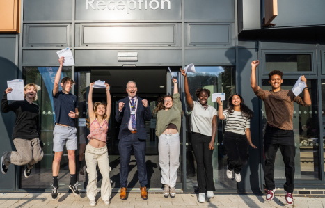 Students jump in the air to celebrate their results