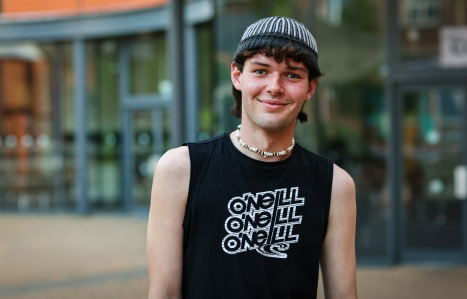 A male student smiles at the camera
