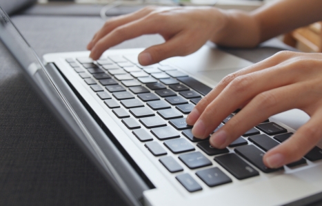 Hands working on notebook computer