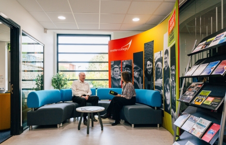 two adults sat chatting in the adult learning hub