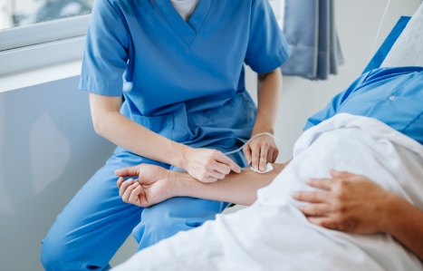 Image of a medical professional withdrawing a needle from a patient