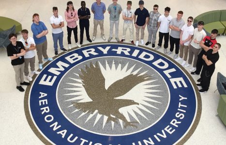 Aerospace students standing in around the Embry-Riddle aeronautical university logo