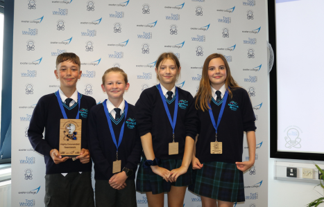 Four secondary school aged children stood side by side smiling at the camera holding their award for the Innovation Competition.