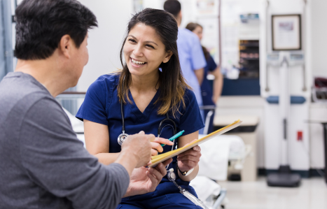 A healthcare professional sits with a patient