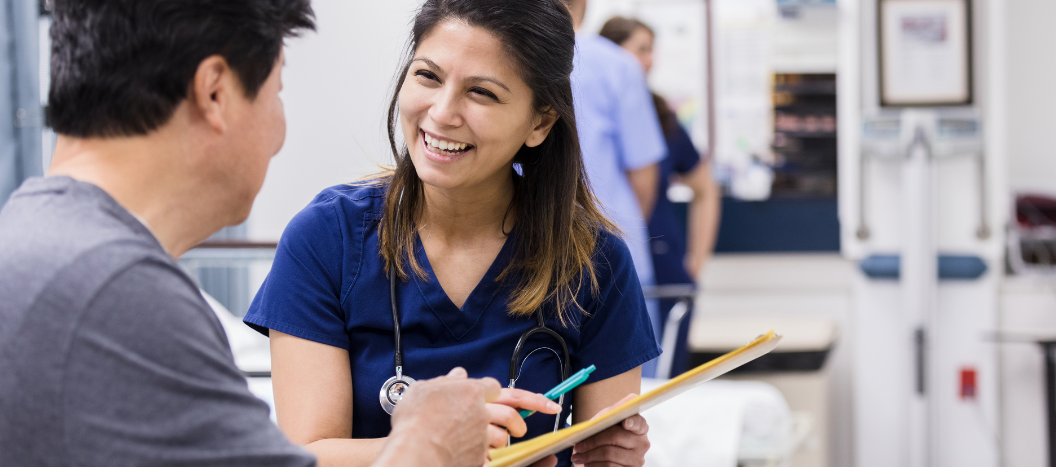 A healthcare professional sits with a patient