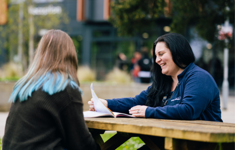 Student and member of staff talking outside