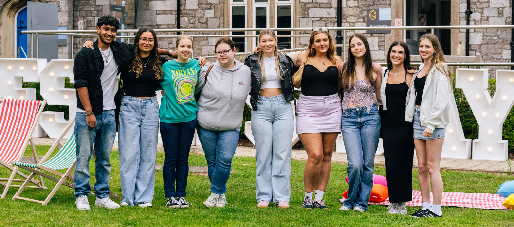 Group of students stop side by side smiling at the camera on results day