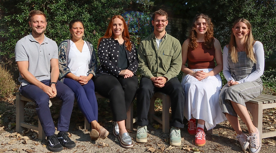 Our College Advisors Team sat on a bench outside smiling at the camera