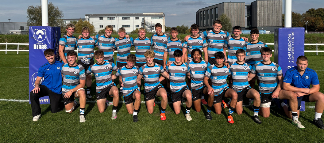 A male rugby team pose in their kit.
