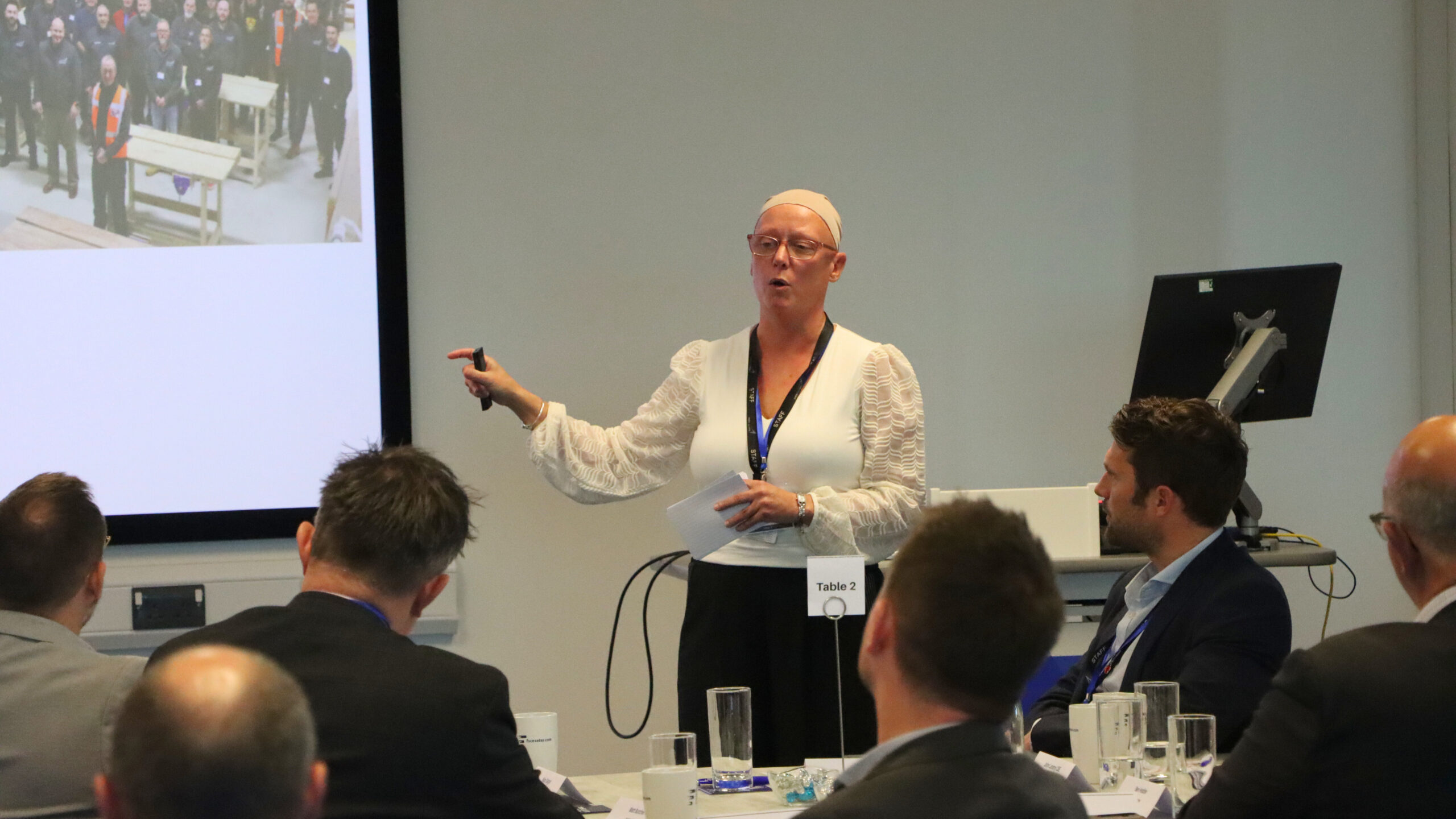 Woman presents to a room of people. 