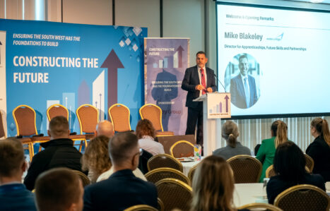 Speaker presents from a podium on a stage.