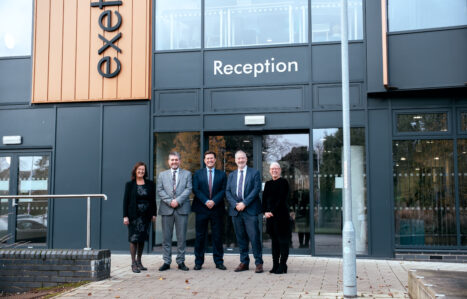 A group of people pose in front of a building