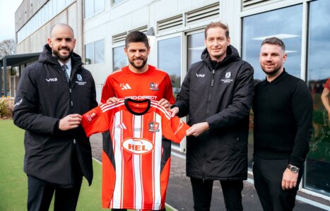 Exeter College sports staff and Exeter City FC staff holding Exeter City FC football kit with the sponsored Exeter College Logo on the sleeve