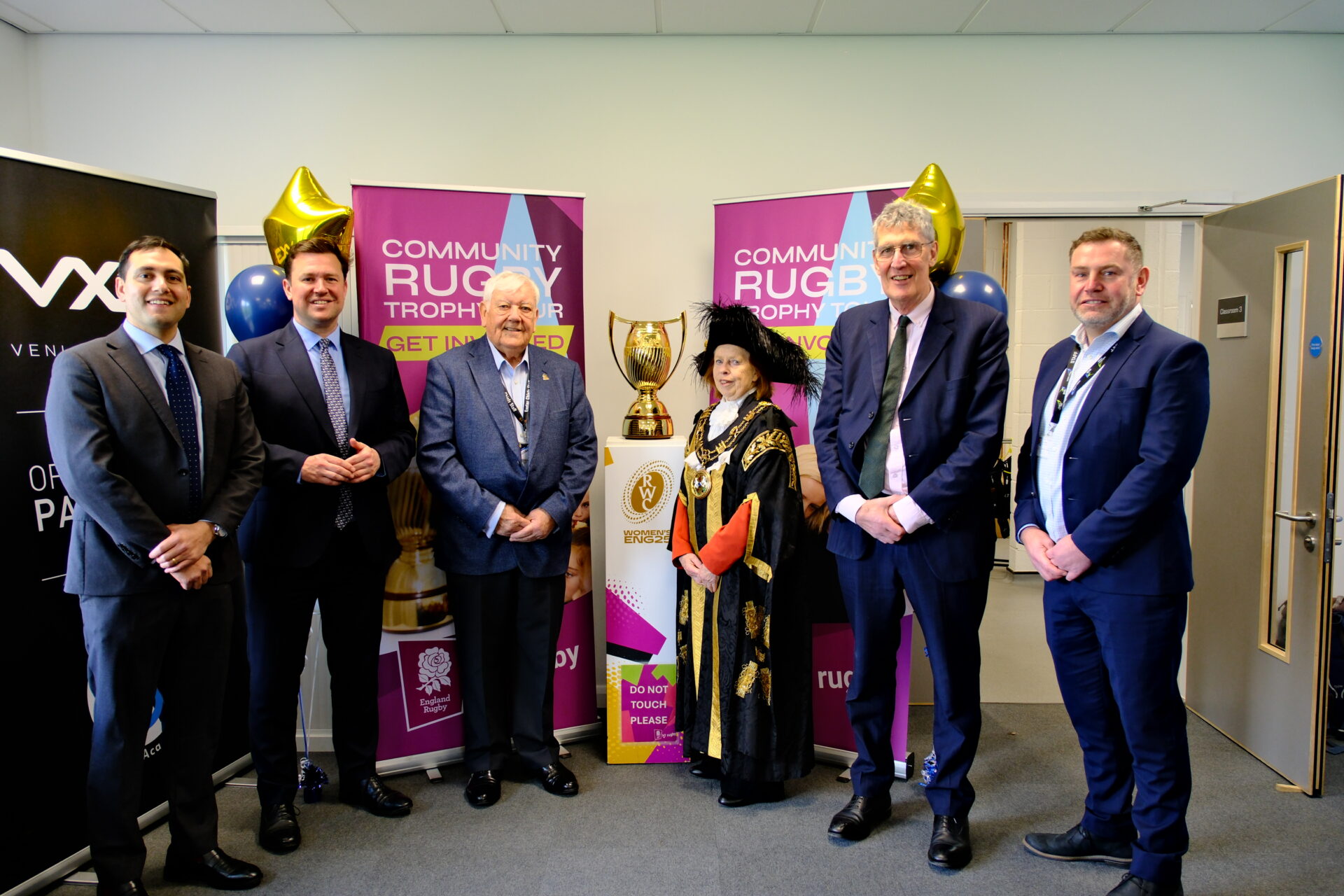 Six people pose infront of a trophy at Exeter College