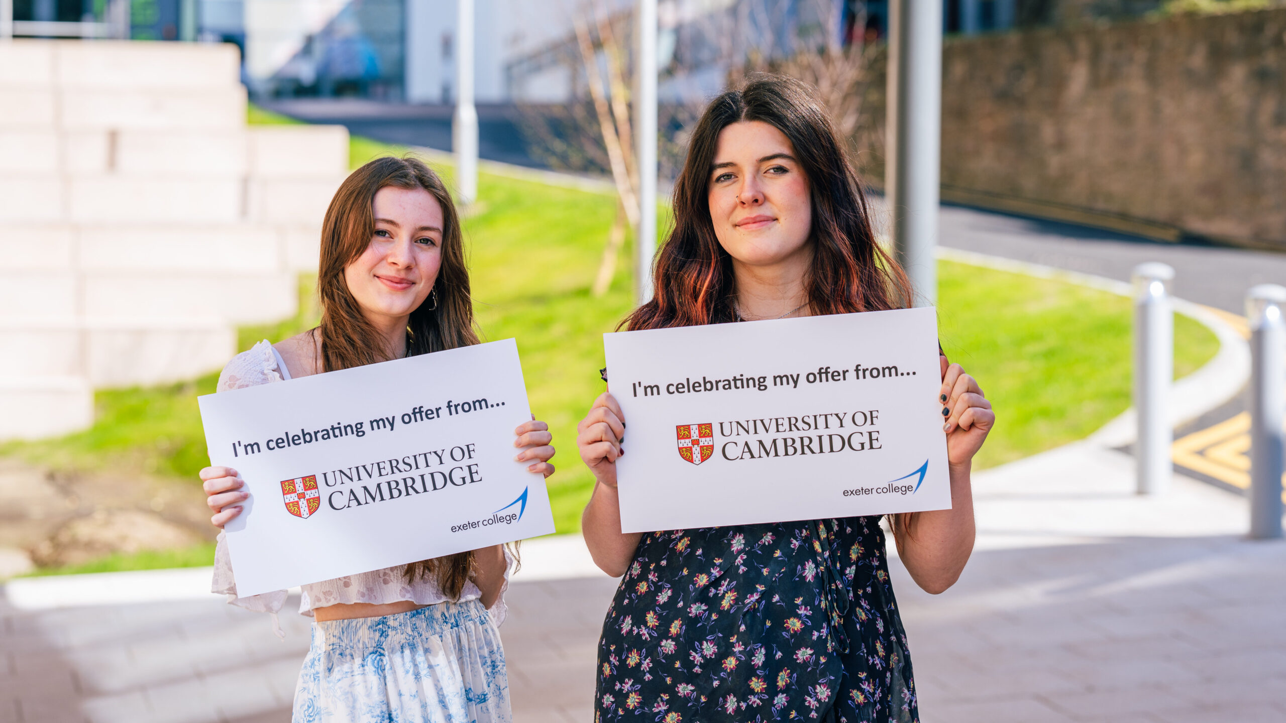 Two Exeter College students holding up signs