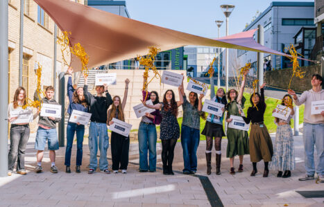 Exeter College students holding up signs